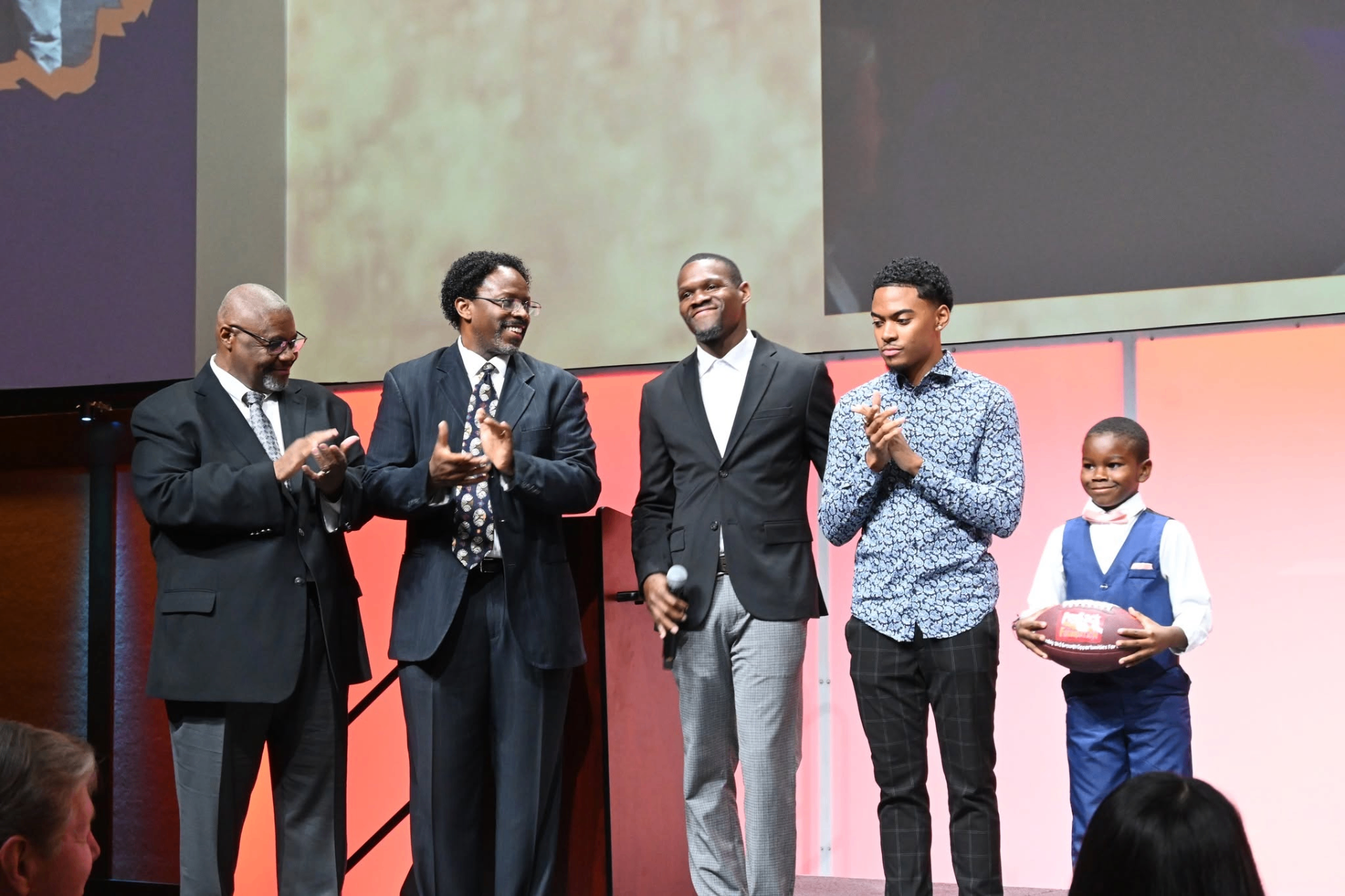UpLift alumni and students on stage at Breakfast of Champions